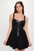 Woman wearing LuxeHaven™ black front ribbon tie bustier mini dress