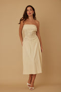 Woman wearing LuxeHaven flower lining linen pattern strapless dress with fitted bodice and flowing summer silhouette