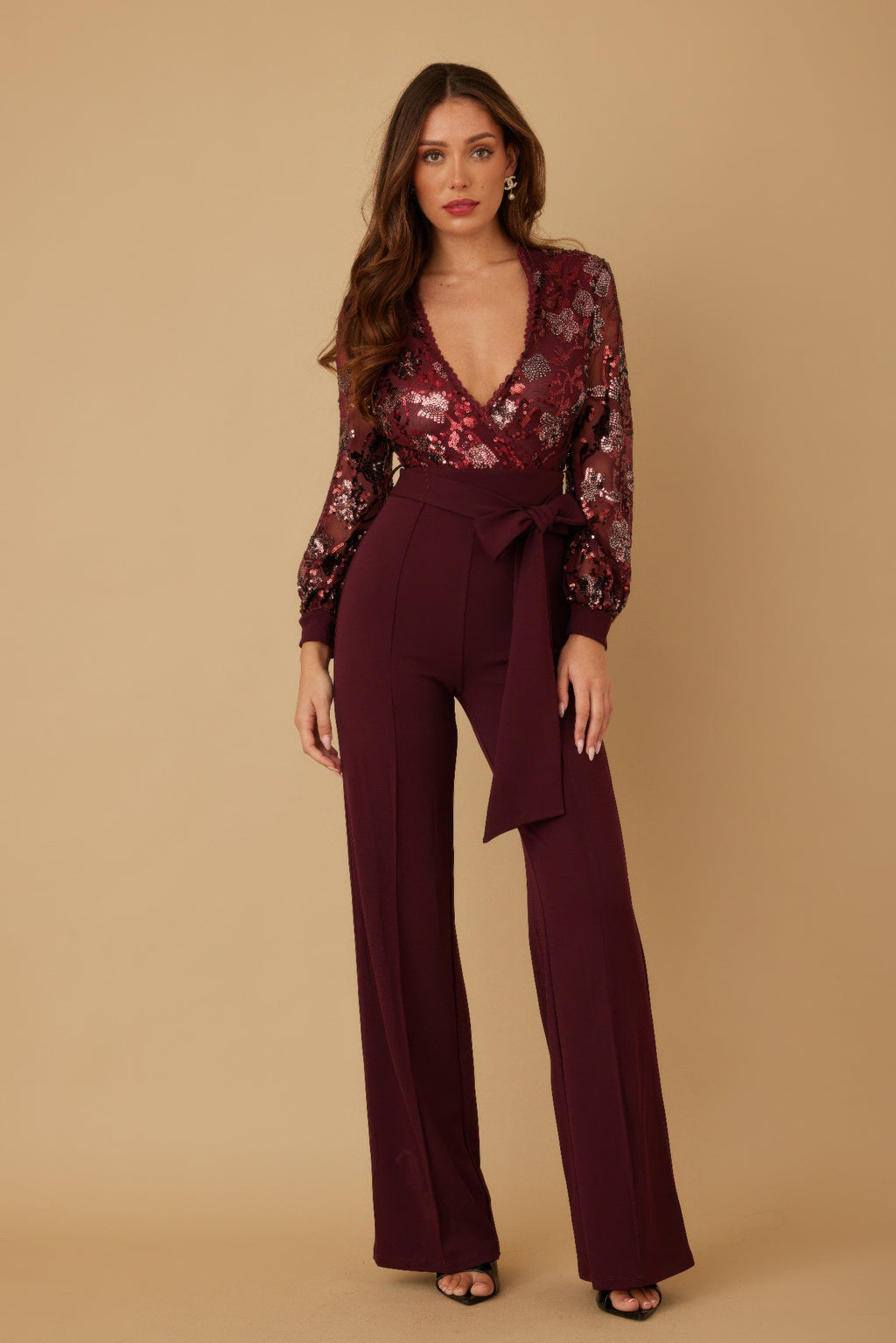 Woman wearing LuxeHaven flower vein sequin print jumpsuit with deep V neckline and colorful floral sequins