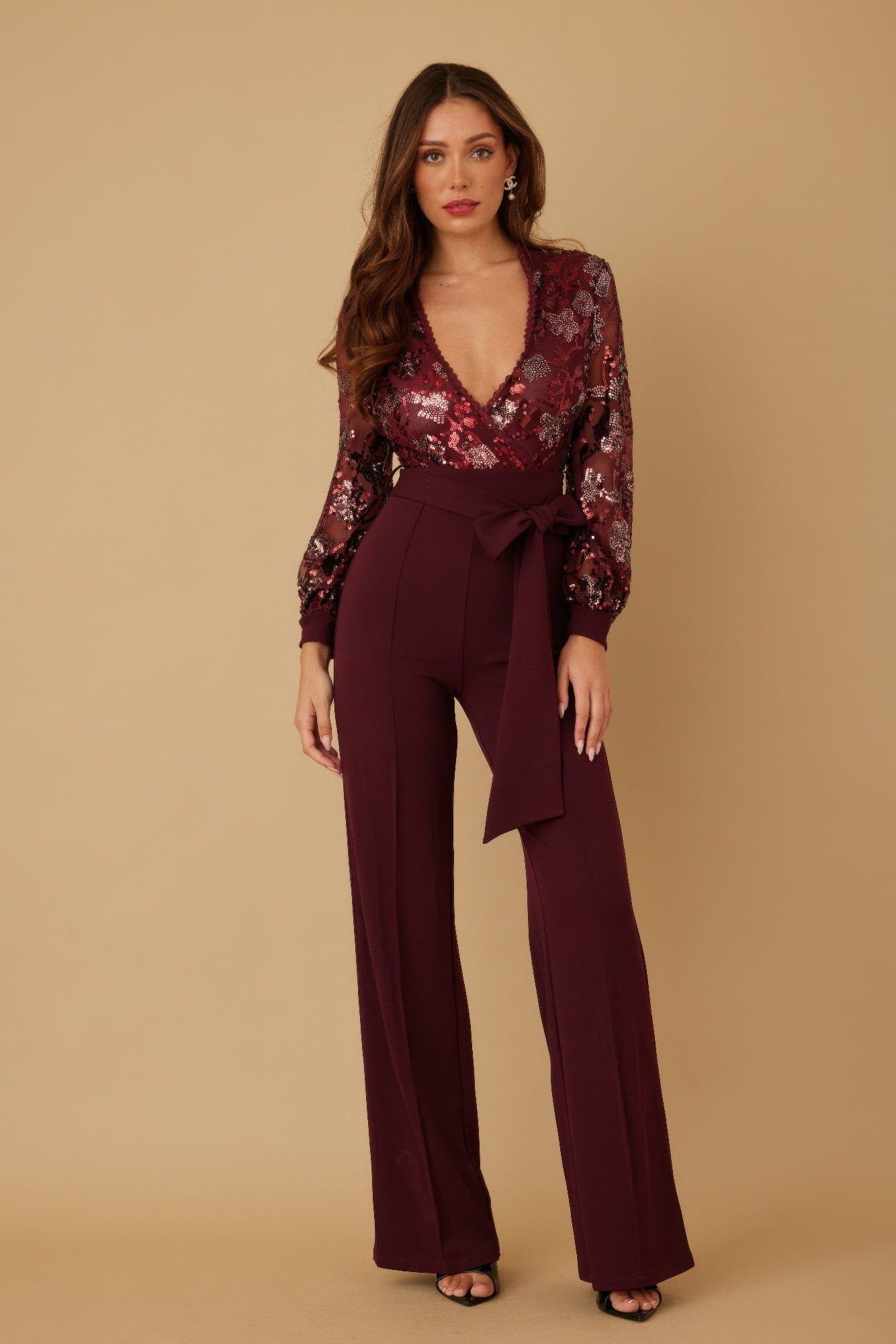 Woman wearing LuxeHaven flower vein sequin print jumpsuit with deep V neckline and colorful floral sequins
