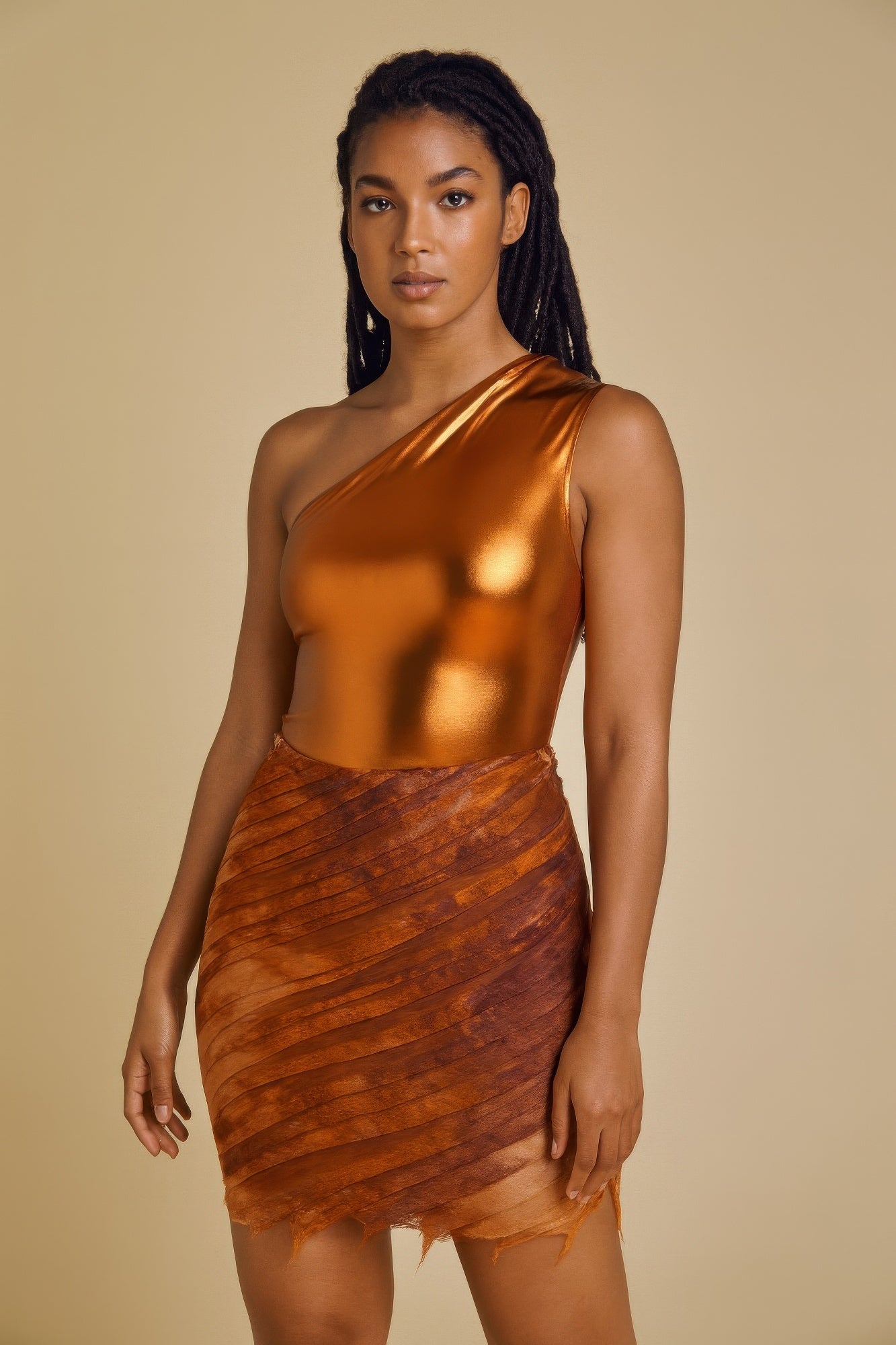 Woman wearing a metallic one shoulder bodysuit with matching mini skirt set for a glamorous party look