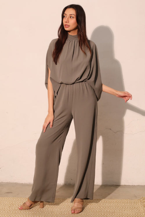 Woman wearing LuxeHaven™ Women's Textured Solid Mock Neck Caftan Jumpsuit with relaxed fit and elegant wide-leg silhouette.