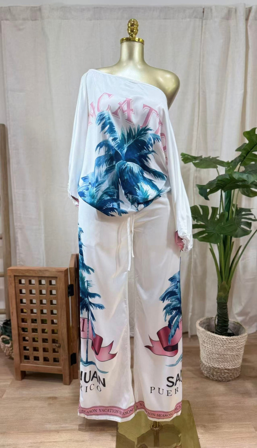 LuxeHaven™ women’s tropical two-piece set featuring one-shoulder long sleeve top, wide-leg pants, and bold palm print for effortless vacation styling.