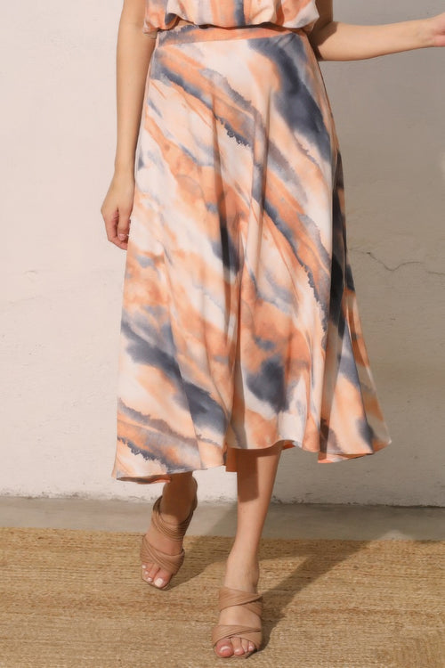 LuxeHaven™ women’s midi swing skirt featuring cloud tie-dye print in peach and grey tones, flowy A-line silhouette, and lightweight fabric for effortless styling.